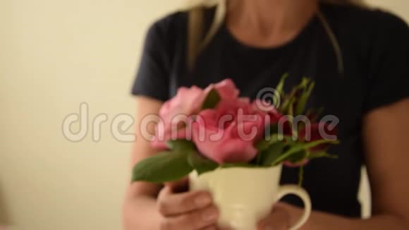 慢动作的年轻女子端着一杯美丽的新鲜玫瑰视频的预览图