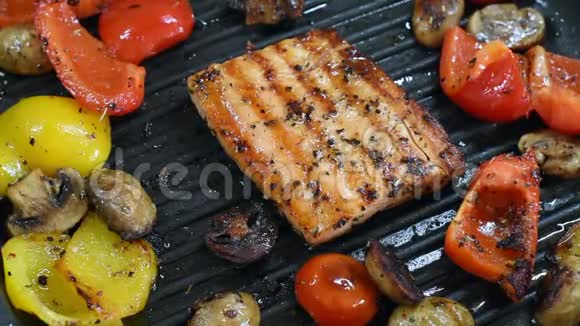 烤架上有美味的鲑鱼和蔬菜烤制方形三文鱼红辣椒和黄椒樱桃视频的预览图