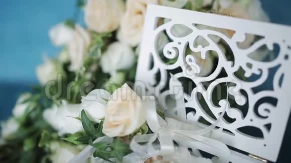 婚礼的概念婚礼戒指放在一个手工制作的木箱里周围是绿松石背景上的花视频的预览图