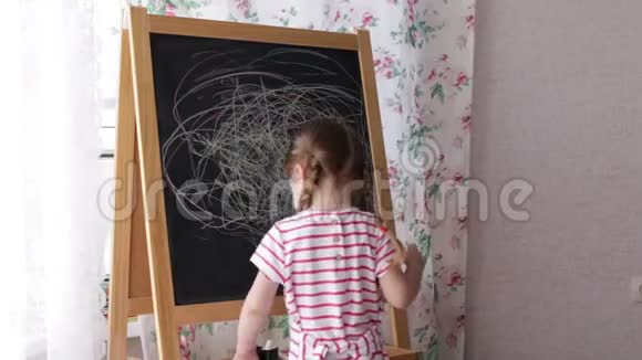 小学前女孩在黑板上写字幼儿女孩拿着粉笔画画视频的预览图