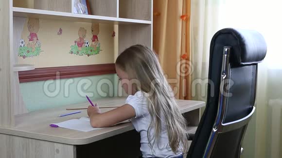 左撇子女孩坐在桌子旁的椅子上用钢笔在纸笔记本上写字回学校去年轻的白种人视频的预览图