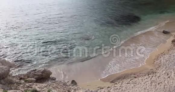 浪流到海滩上贝拉在蓝色的海水上起泡温暖阳光的小窝里充满咸味的海洋安静的度假和休息场所视频的预览图