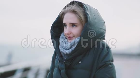 秋日寒冷的户外穿着暖和的衣服的迷人年轻女子的肖像视频的预览图