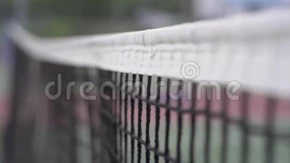 网球比赛前景是网球场和球场上的网格幕后的运动员抛出一个视频的预览图