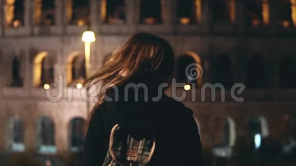 站在意大利罗马斗兽场附近的年轻美女在镜头前回首在晚上微笑视频的预览图