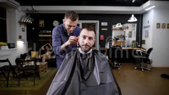 一位时尚的理发师与一位美容院的访客交谈她来理发店理发理发店里的客人正在给理发视频的预览图