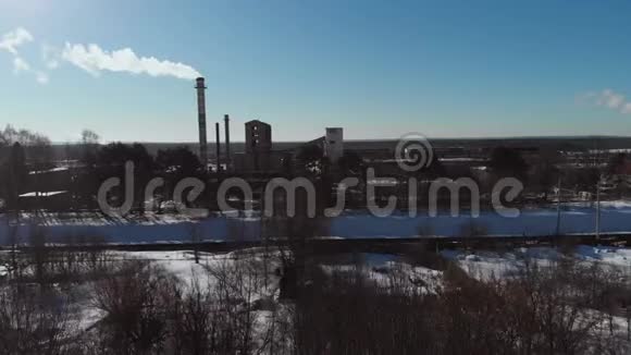 雪的冬天里的老企业建筑基地机库空中射击污染空气的烟囱管式锅炉赢了视频的预览图