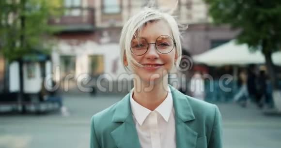 站在街上笑着的活泼金发女郎的慢镜头画像视频的预览图