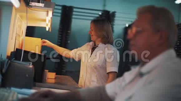 穿白色长袍的女人在实验室里用橙色塑料托盘视频的预览图