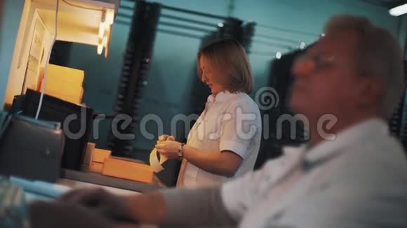 穿白色长袍的女人在实验室用塑料托盘开处方视频的预览图