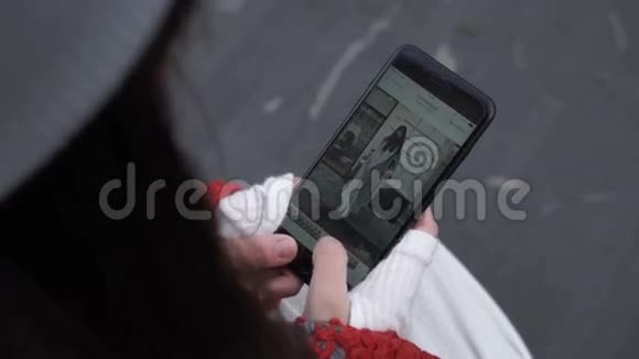 女性在智能手机上浏览照片视频的预览图