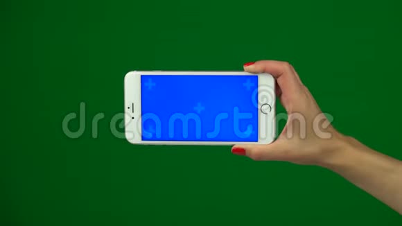 手拿着蓝色屏幕智能手机在绿色屏幕上视频的预览图