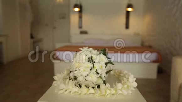 新娘婚礼花束和夏威夷雷花圈由白色兰花在桌子上的房间不是人滑块摄像头视频的预览图