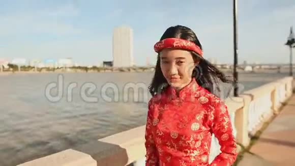 穿着民族服装的亚洲女孩和穿着越南傣族服装沿着河堤岘港散步视频的预览图