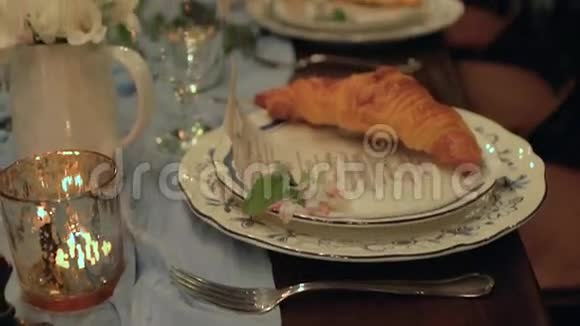 慢倾斜的节日桌与服务牛角面包蜡烛马卡龙花视频的预览图