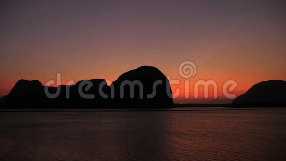浪漫的紫色日落在群山之外的大海上视频的预览图