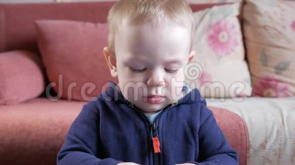 一个有魅力的男孩2岁他在家里的一张桌子上用一种多色的塑料制品塑造自己结果发现视频的预览图