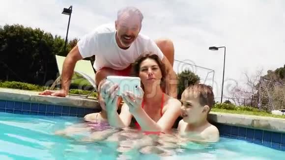 一家人在泳池边用手机自拍视频的预览图