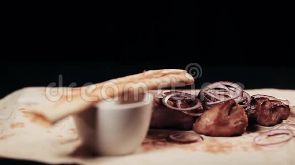把食物夹起来现成的什什烤串肉串洋葱和草药放在皮塔面包上视频的预览图