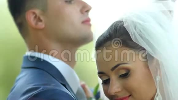 美丽的新婚夫妇轻轻拥抱恋爱中的年轻夫妇婚礼当天视频的预览图