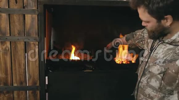 铁匠在传统铁匠铺壁炉边的冷油中手工锻造钢刀视频的预览图