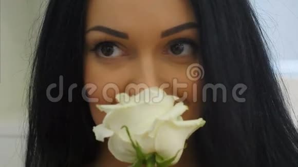 年轻女子闻着白玫瑰和微笑视频的预览图