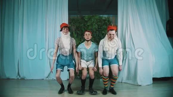 三个穿着侏儒服装的滑稽男子同时跳跃双手惊讶视频的预览图