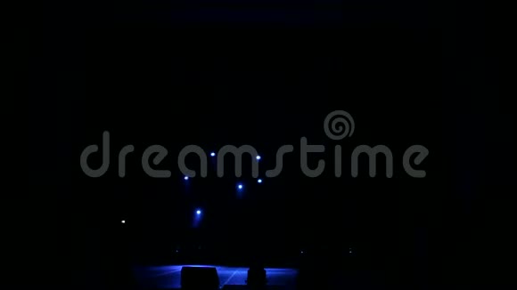 蓝色的光线在黑暗中交替地在舞台上闪现空的音乐会舞台视频的预览图