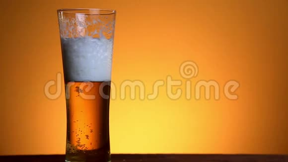 啤酒倒在黄色背景的玻璃上视频的预览图