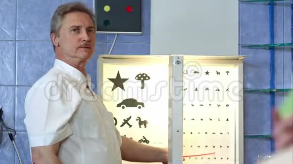 老年男性眼科医生指着眼图视频的预览图