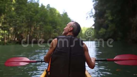 人在皮划艇上沿着河游视频的预览图