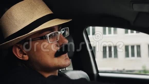 戴着胡子戴着帽子戴着眼镜坐在车里的成年人夏日仿造视频的预览图