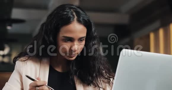 商务女性坐在咖啡馆里拿着笔记本电脑吃晚饭桌上放着一杯茶上班吃午饭视频的预览图
