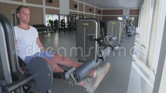 在健身房里男人专注于训练机器上的腿视频的预览图