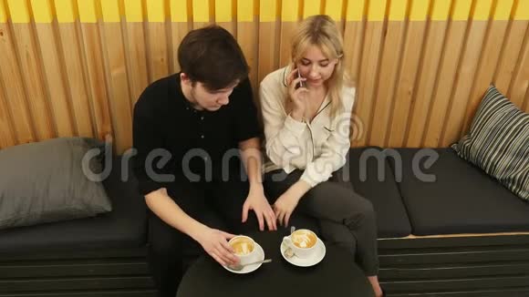 年轻开朗的女人在咖啡店约会时通过手机聊天视频的预览图