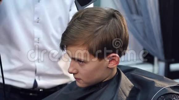 理发师用吹风机把头发给男孩视频的预览图