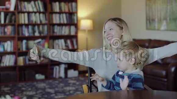年轻的母亲和儿子在沙发上自拍家庭幸福视频的预览图