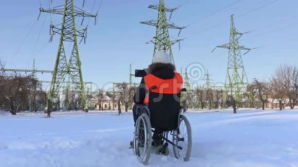 轮椅上的残疾工人在高压线附近拍照视频的预览图