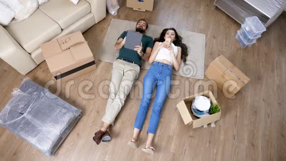 年轻夫妇躺在新公寓的地板上视频的预览图