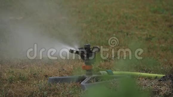 割草机在绿草上喷水草坪灌溉系统视频的预览图