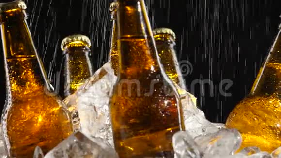 啤酒站在冰上水从上面流出来溅落在玻璃上黑色背景关门视频的预览图