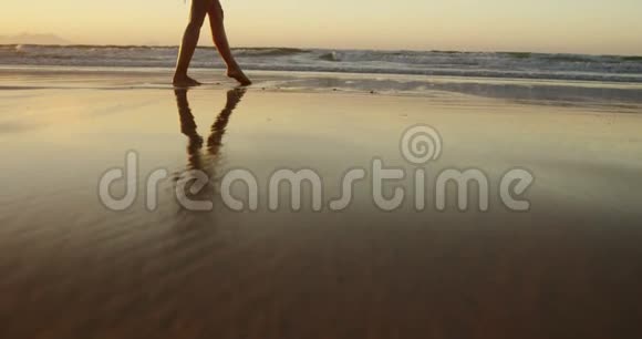 双臂伸展的女人在沙滩上散步视频的预览图