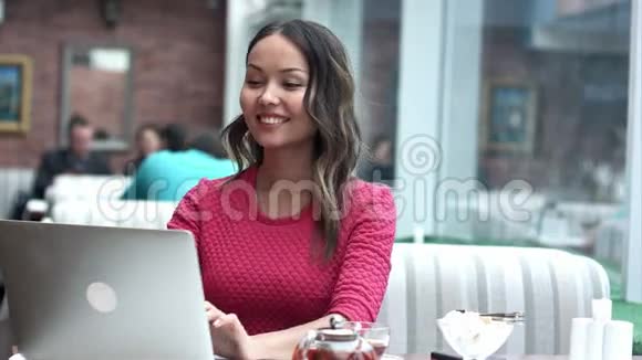 女人在咖啡馆里通过视频电话进行商务会议视频的预览图