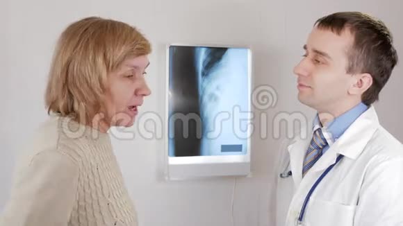 一位在医生接待年老的妇女咳嗽和谈论健康问题他说出了诊断视频的预览图