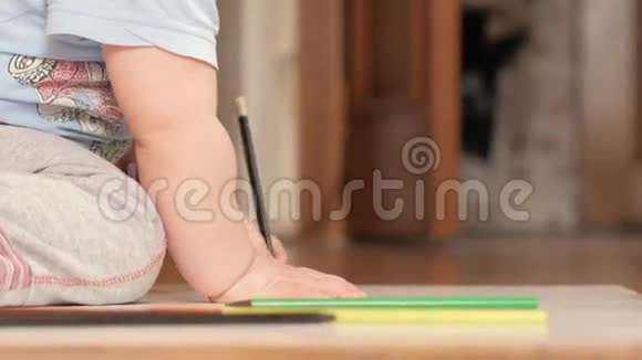 一个2岁的男孩在家里用彩色铅笔画画手里是黑色的视频的预览图