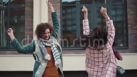 两个无忧无虑的年轻女人在街上玩得很开心跳舞女朋友在一起玩得很开心女孩们正在散步视频的预览图