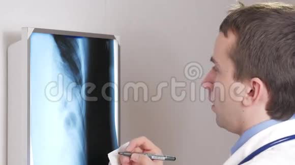 一位年轻的医生用钢笔在纸上写下病人x光的结果肋骨的X光片特写视频的预览图