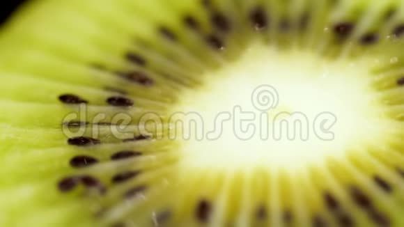 一只猕猴桃在黑色背景上特写黑色背景上的多汁绿色猕猴桃快点吃水果猕猴桃躺在视频的预览图