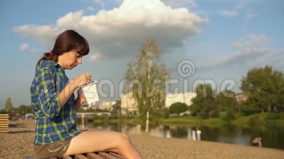 女孩在鹅卵石滩吃热面条视频的预览图