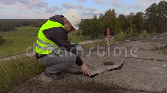 使用平板电脑操作大锤的工人靠近破碎的混凝土板视频的预览图